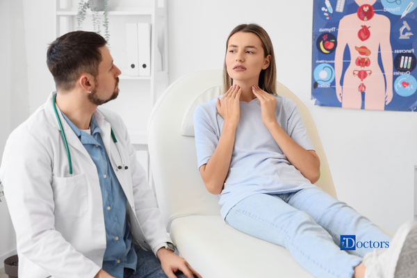 Una paziente durante una visita endocrinologica, mentre il medico valuta la zona della tiroide.
