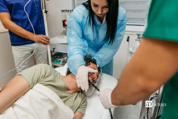 Paziente durante l’esecuzione di una gastroscopia con l’assistenza del personale sanitario.