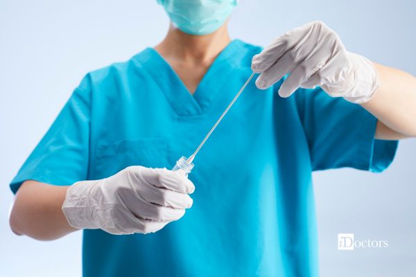 Operatrice sanitaria con guanti e mascherina tiene in mano un tampone sterile