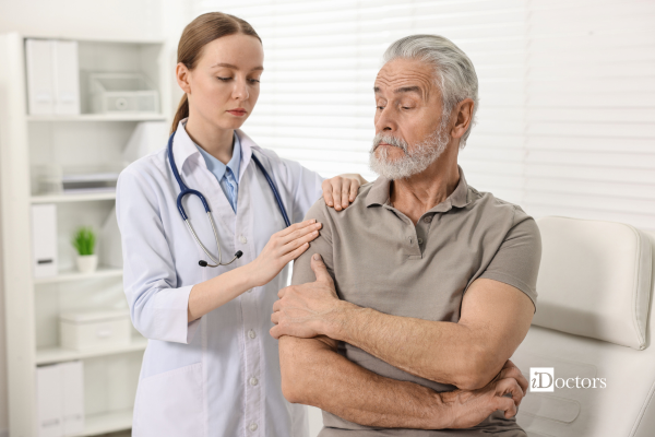 Un medico valuta il dolore alla spalla di un paziente durante una visita specialistica.