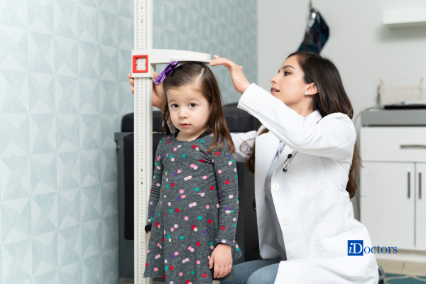 Dottoressa che sta misurando l'altezza di una bambina.