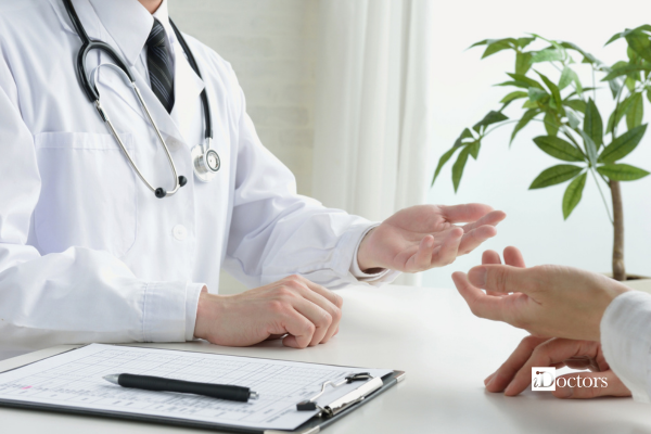 Dottore e paziente seduti con davanti una cartella clinica.