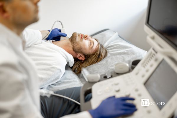 medico esegue ecocolordoppler della carotide a paziente disteso sul lettino