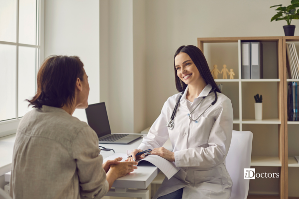 Un medico e una paziente durante un colloquio in studio medico, con la consultazione della documentazione sanitaria.