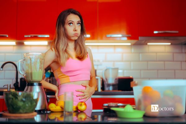 Donna in cucina con alimenti per dieta per stipsi e ragadi