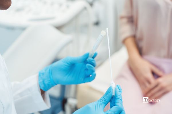 Professionista sanitario mostra un tampone vaginale a una paziente.