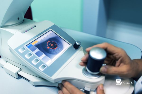 Operatore regola lo strumento per la pachimetria ottica, con l’immagine della cornea visibile sul monitor.