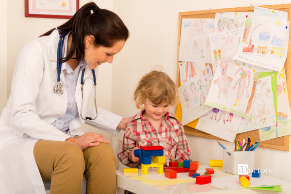 Dottoressa mentre osserva il comportamento di un bambino durante una visita specialistica. 