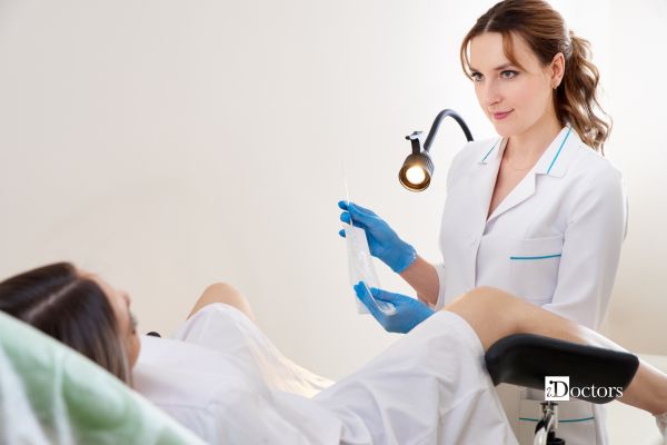Ginecologa esegue il tampone cervico-vaginale ad una paziente distesa sul lettino