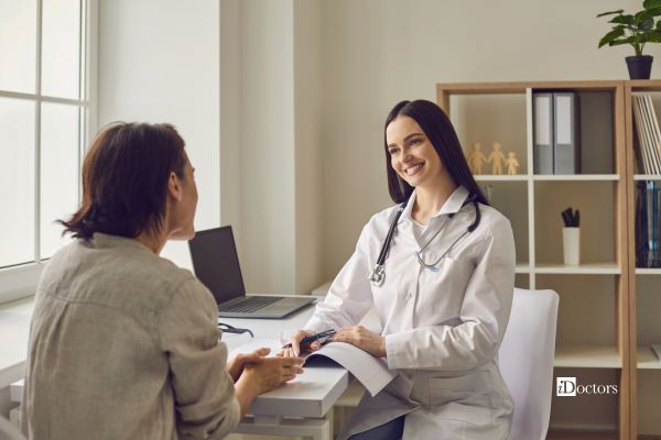 Medico a colloquio con una paziente durante una visita nutrizionale con schema dietetico.