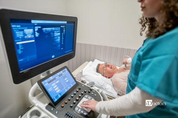 Cardiologo esegue l'ecocardiogramma a paziente disteso sul lettino
