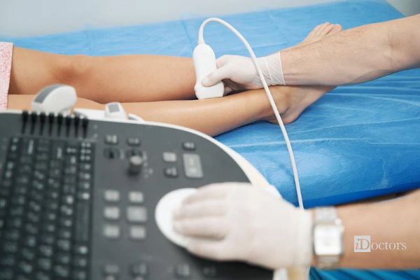 EcoColorDoppler arterioso degli arti inferiori con sonda appoggiata sulla gamba del paziente disteso sul lettino.